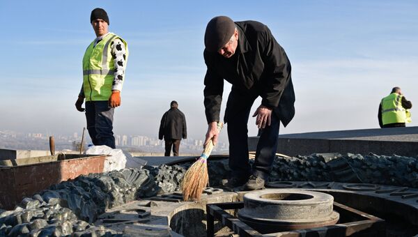 Работники Киевгаз очищают вновь залитый цементом мемориал Вечный огонь в парке Славы в Киеве. 20 ноября 2017
