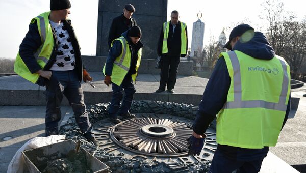 Работники Киевгаз о время работ по очищению вновь залитого цементом мемориала Вечный огонь в парке Славы в Киеве. 20 ноября 2017