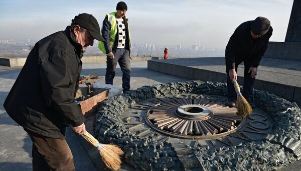 Работники Киевгаз очищают залитый цементом мемориал Вечный огонь. Архивное фото