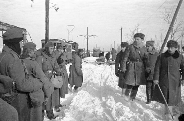 Советские офицеры проходят мимо немецких пленных. Сталинград, январь 1943 года