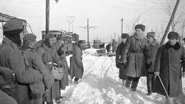 Советские офицеры проходят мимо немецких пленных. Сталинград, январь 1943 года