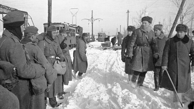 Советские офицеры проходят мимо немецких пленных. Сталинград, январь 1943 года