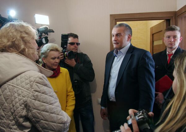 Глава Республики Крым Сергей Аксенов общается с жильцами, въехавшими в новые дома в Крыму, построенные для переселенцев из зоны строительства моста через Керченский пролив Глава Республики Крым Сергей Аксенов общается с жильцами, въехавшими в новые дома в Крыму, построенные для переселенцев из зоны строительства моста через Керченский пролив