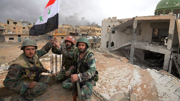 Солдаты сирийской армии с флагом в Пальмире