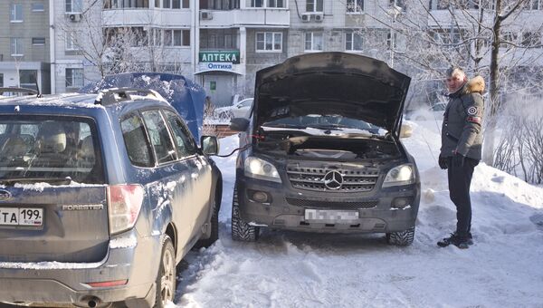 Автомобилист заряжает аккумулятор своего автомобиля в Москве. Архивное фото