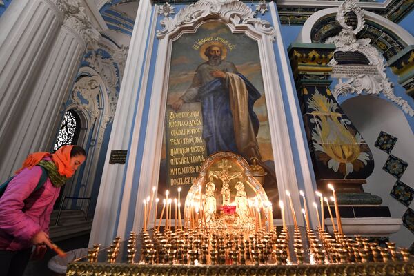 Прихожанка ставит поминальную свечку в Воскресенском соборе на территории Ново-Иерусалимского мужского монастыря