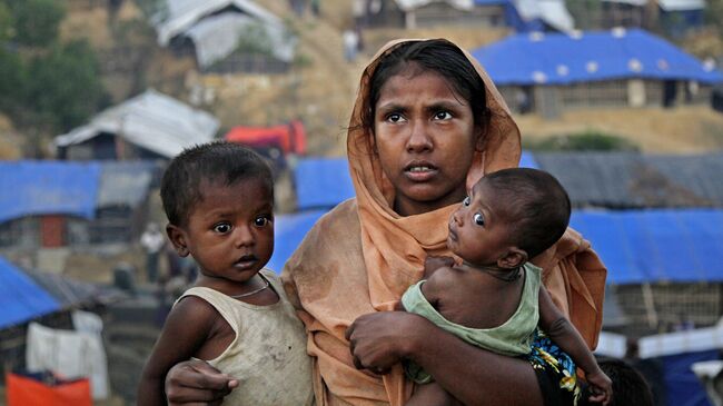 Женщина с детьми в поисках места для жилья в лагере Балухали на границе Мьянмы и Бангладеш