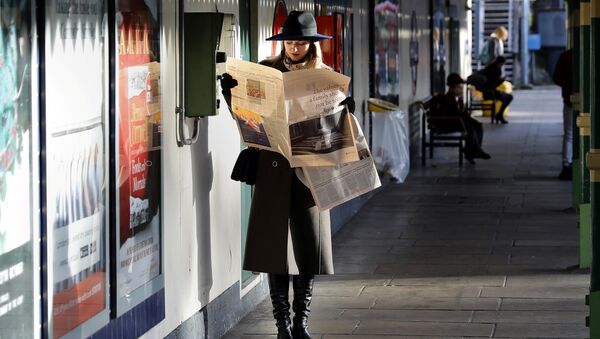 Женщина читает газету в метро Лондона