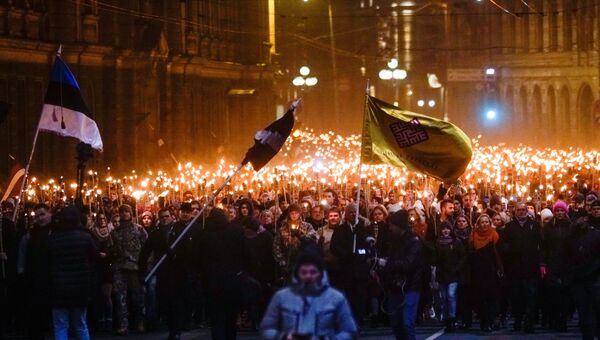 Участники факельного шествия в честь Дня независимости Латвии в Риге