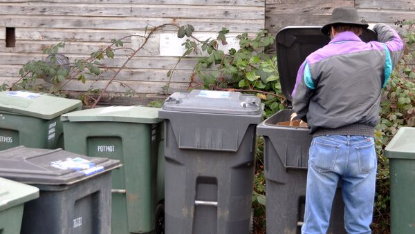 Мужчина рядом с мусорными контейнерами. Архивное фото