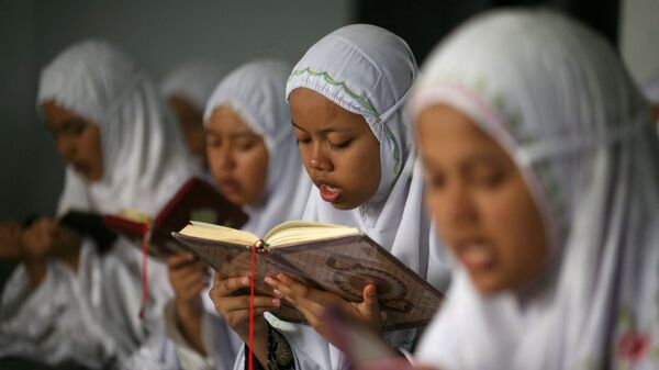 Школьницы читают Коран в исламской школе-интернате в Индонезии