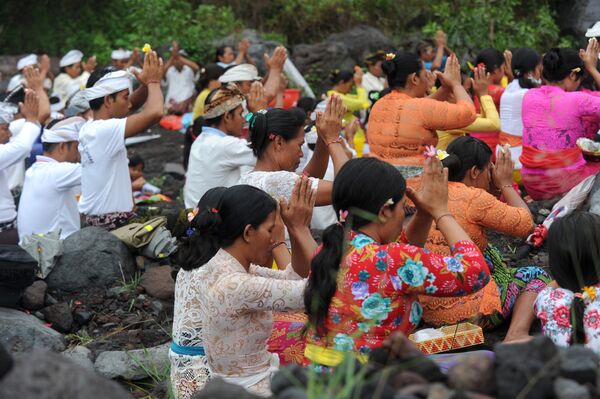 Люди во время молитвы возле вулкана Агунг на острове Бали в Индонезии