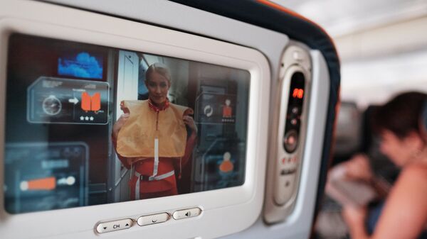 Демонстрация действий при аварии на экране кресла в салоне самолета авиакомпании