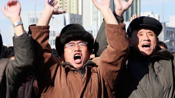Люди приветствуют сообщение о пуске баллистической ракеты Хвансон-15 в Пхеньяне