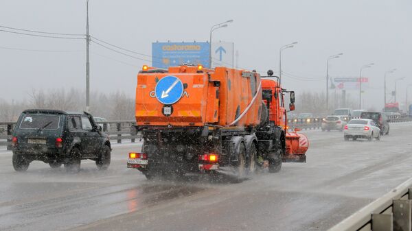 Снегоуборочная машина обрабатывает улицу противогололедным средством в Москве. Архивное фото