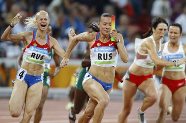 Российские спортсменки Юлия Гущина и Юлия Чермошанская (слева направо) завершают женскую эстафету 4x100 м