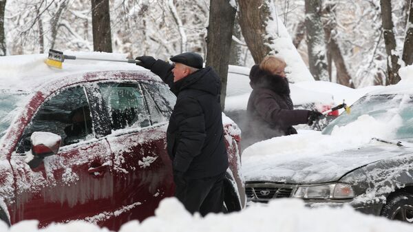 Горожане очищают личные автомобили от снега. Архивное фото