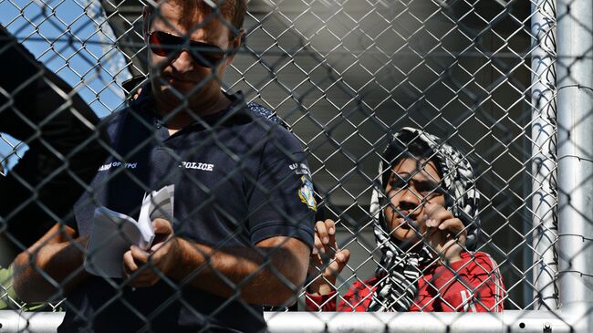 Полицейский в лагере беженцев с Ближнего Востока на острове Лесбос в Греции