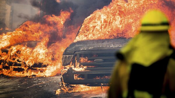Автомобили,  охваченные пламенем от лесного пожара, в городе Вентура в Калифорнии, США