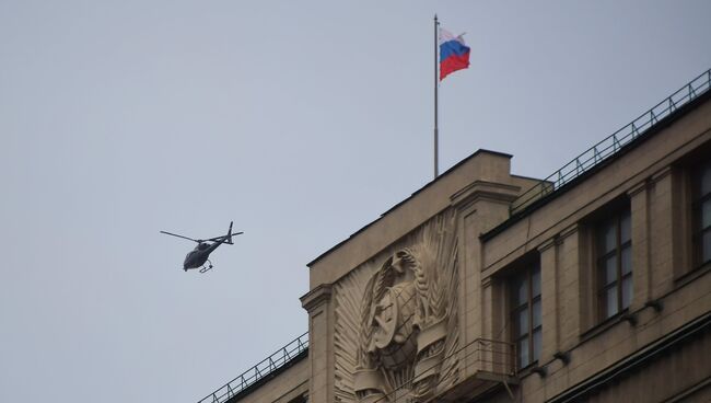Вертолет пролетает над зданием Государственной Думы РФ