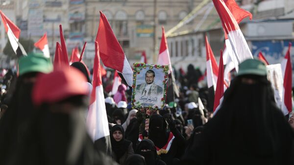 Сторонники хуситов с портретом лидера повстанцев Абдул-Малика аль-Хуси во время празднования убийства президента Йемена Али Абдалла Салеха на улице Саны. 5 декабря 2017