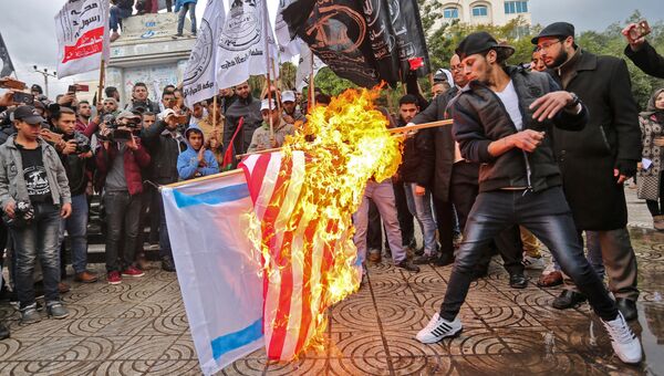 Палестинские протестующие сжигают американский и израильский флаги в городе Газа