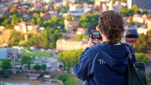 Женщина фотографирует Тбилиси