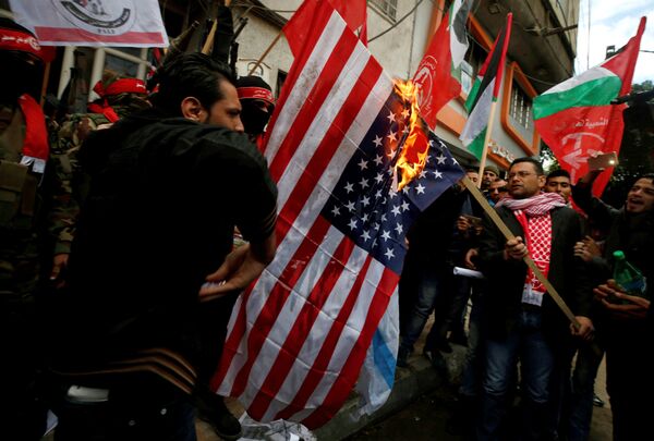 Палестинцы сжигают флаг США во время протеста против решения президента США Трампа признать Иерусалим столицей Израиля в городе Газа Палестинцы сжигают флаг США во время протеста против решения президента США Трампа признать Иерусалим столицей Израиля в городе Газа