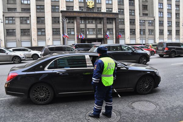 Сотрудник дорожно-патрульной службы на дороге перед зданием Государственной Думы РФ на улице Охотный ряд в Москве Сотрудник дорожно-патрульной службы на дороге перед зданием Государственной Думы РФ на улице Охотный ряд в Москве