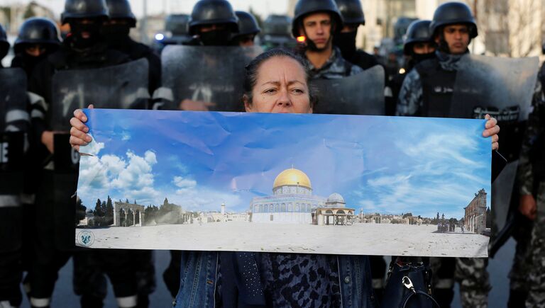 Протестующая держит плакат с изображением мечети Эль-Акса во время протеста возле американского посольства в Аммане, Иордания. 7 декабря 2017