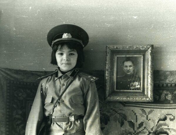 Автор книги позирует на фоне фотографии своего деда, полковника Льва Пунина. Ленинград, 1987 г.