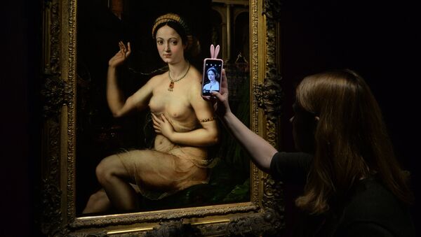 Девушка фотографирует картину Джулио Романо Дама за туалетом, или Форнарина. Архивное фото
