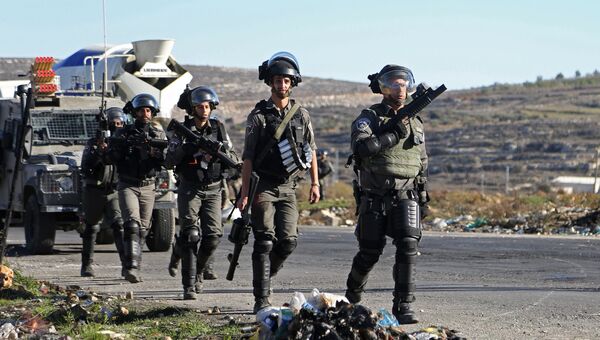Сотрудники правоохранительных органов Израиля во время столкновений на границе Палестины и Израиля около Рамаллы. 9 декабря 2017
