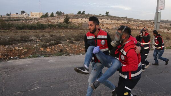 Сотрудники медицинской службы эвакуируют пострадавшего на границе Палестины и Израиля. Архивное фото