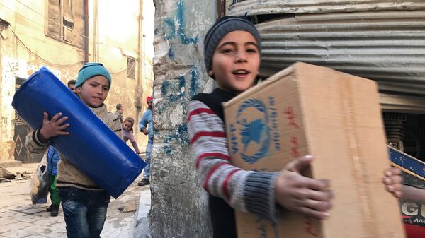 Дети, получившие первую гуманитарную помощь, в восточном квартале Алеппо. Архивное фото