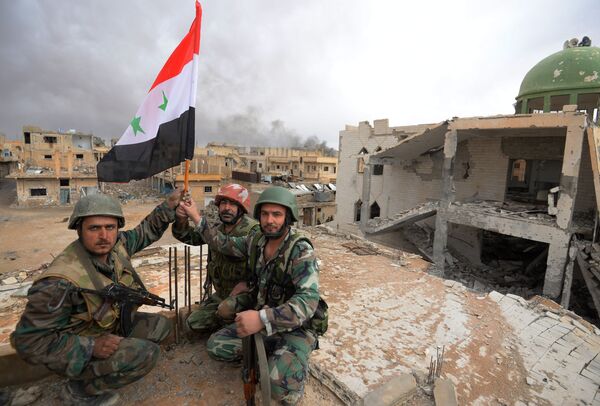 Солдаты сирийской армии (САА) с флагом Сирии радуются освобождению Пальмиры