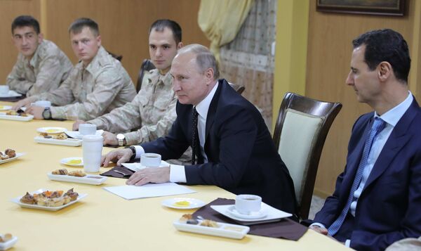 Президент РФ Владимир Путин и президент Сирийской Арабской Республики Башар Асад (справа) во время общения с военнослужащими авиабазы Хмеймим в Сирии