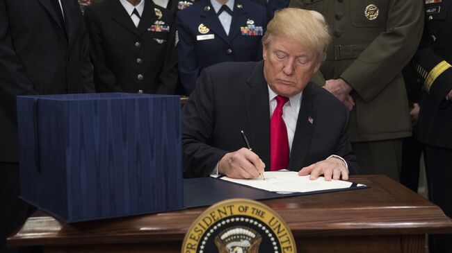 Президент США Дональд Трамп подписывает оборонный бюджет страны на 2018-й финансовый год в Белом доме, Вашингтон. 12 декабря 2017