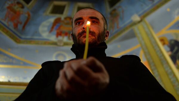 Верующий во время пасхальной службы в церкви Михаила Архангела в Грозном