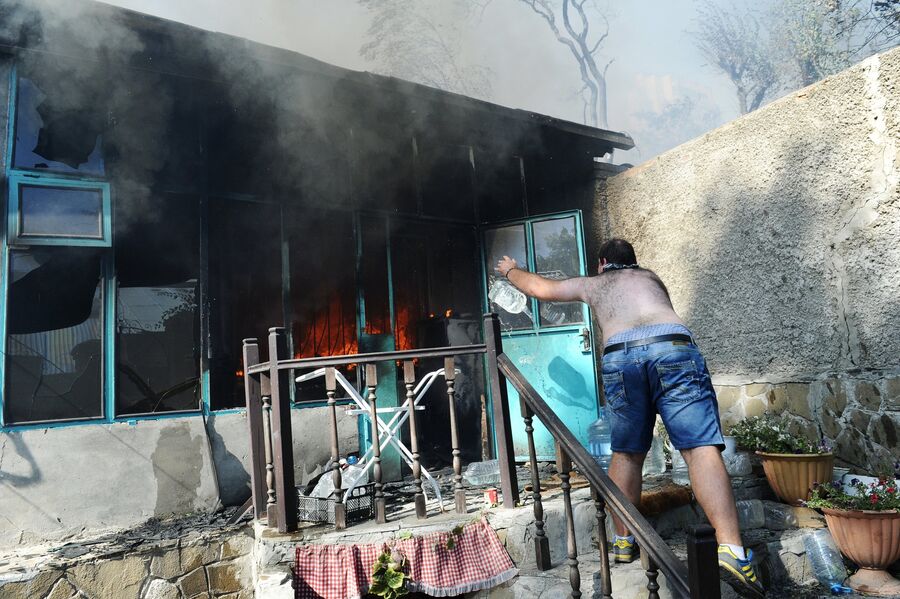 Мужчина тушит пожар в жилом секторе Ростова-на-Дону