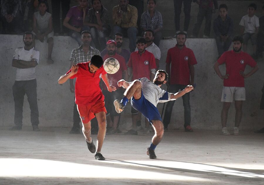 Игроки во время футбольного матча между командами сотрудников общества Красного Креста и Красного Полумесяца и студентами в сирийском городе Дейр-эз-Зор