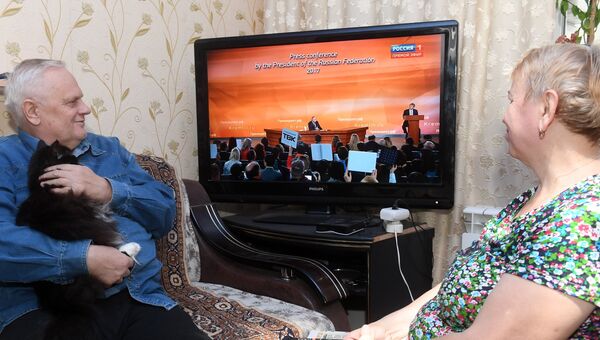 Семья пенсионеров в Казани смотрит по телевизору трансляцию пресс-конференции президента РФ Владимира Путина