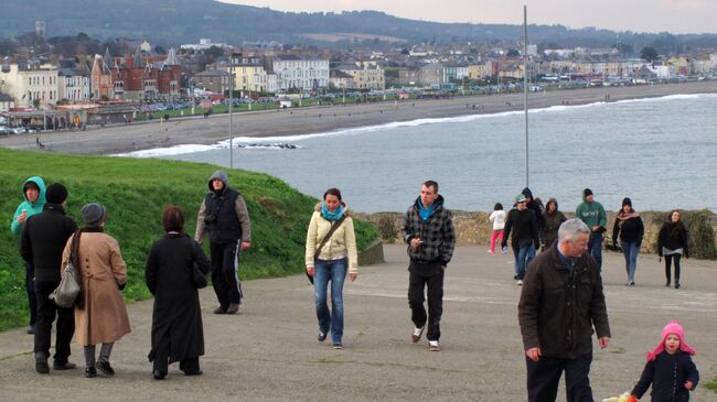 Люди прогуливаются вдоль обрыва Брей-Грейстоун над Ирландским морем возле Дублина