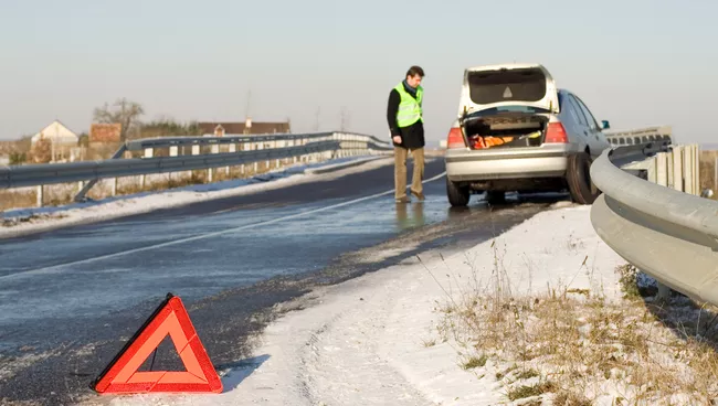 Водитель в светоотражающем жилете у автомобиля