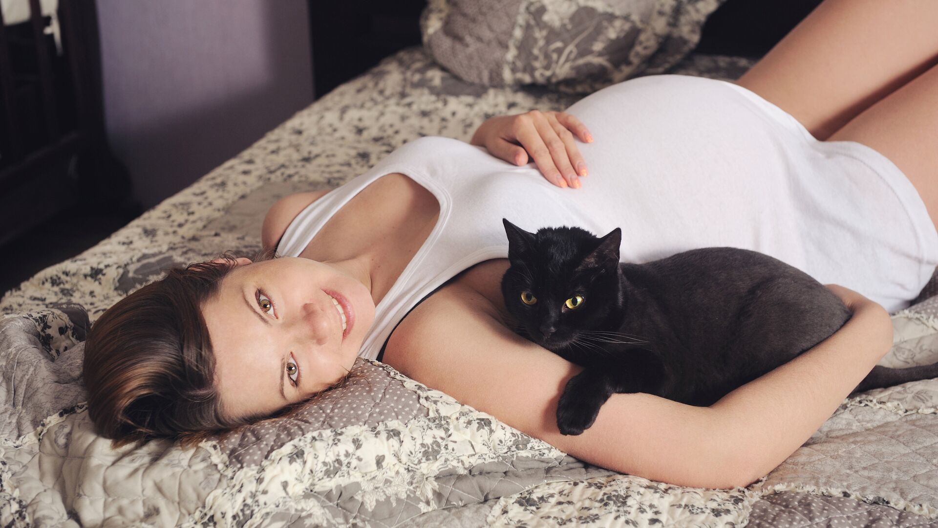 Беременная женщина лежит на кровати с кошкой - РИА Новости, 1920, 02.04.2021