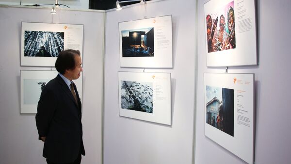 Посетитель на открытии выставки победителей конкурса имени Андрея Стенина в Пекине. 18 декабря 2017