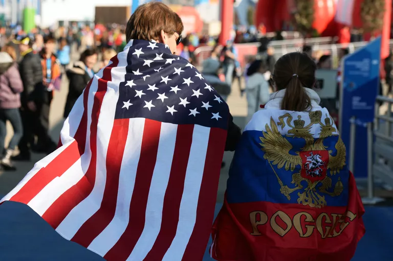 Молодые люди в национальных флагах США и России Молодые люди в национальных флагах США и России