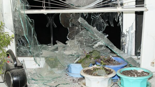 Окно жилого дома, пострадавшего в результате обстрела, в городе Стаханов