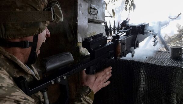 Украинский военный стреляет из пулемета на огневой позиции в Авдеевке