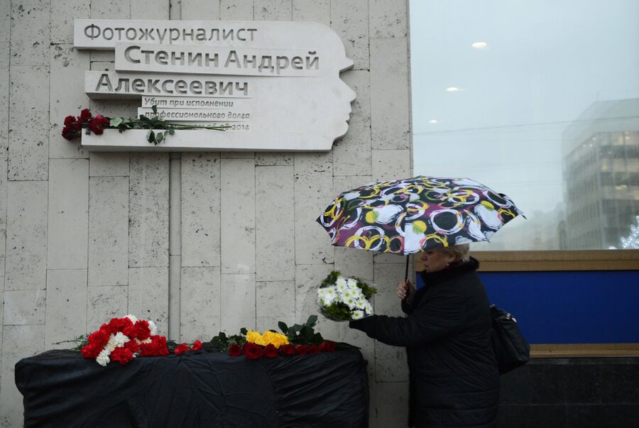 Коллега возлагает цветы к мемориальной доске в честь фотокорреспондента МИА Россия сегодня Андрея Стенина